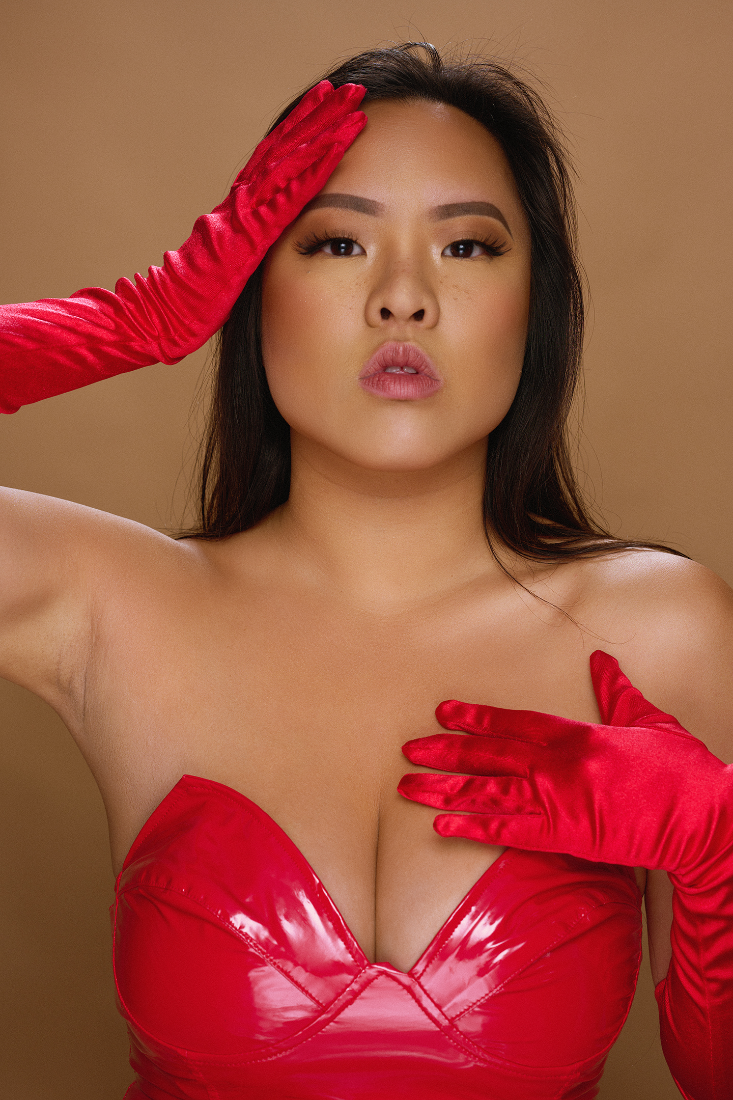 Woman with red gloves in a red strapless top.